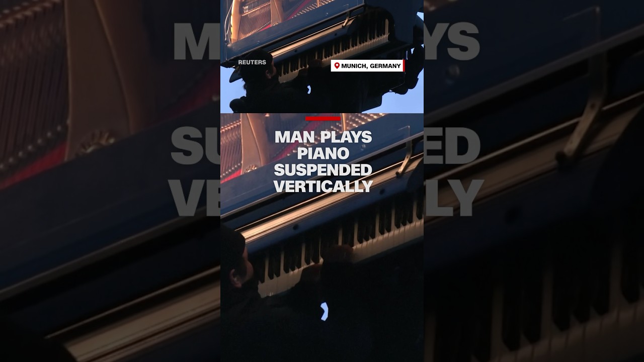 Man plays piano suspended vertically